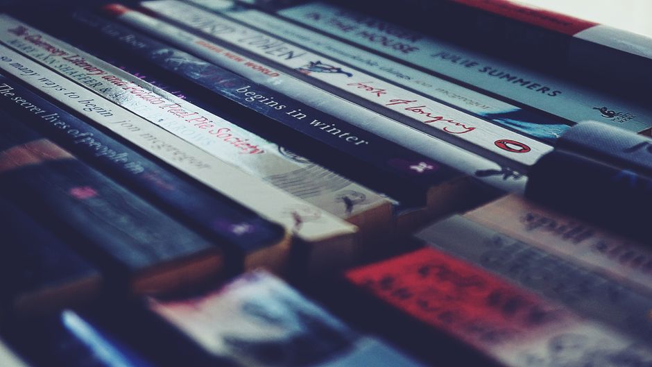 A collection of neatly arranged books on a shelf with visible titles.