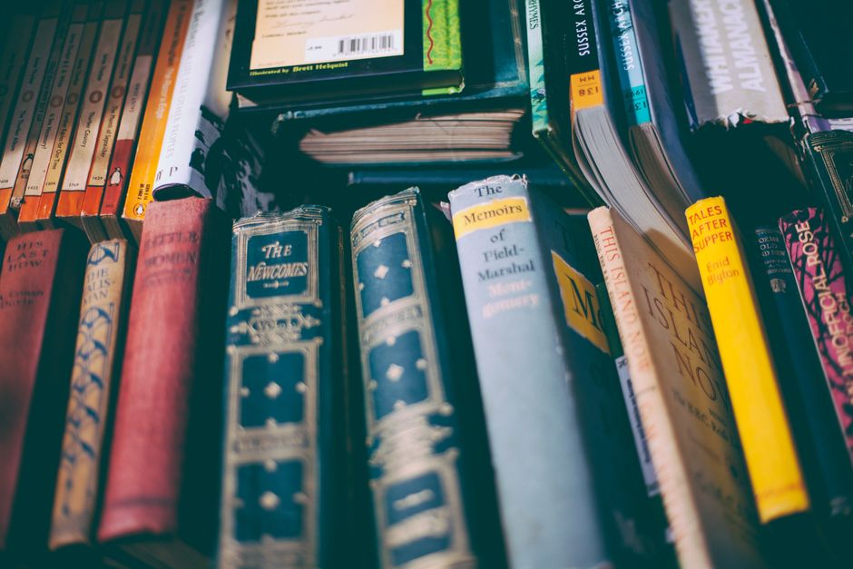 A collection of neatly arranged books on a shelf with visible titles.